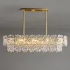 A rectangular chandelier with multiple tiers of clear, faceted glass elements hanging from a gold-colored metal frame. Anteprima dell’immagine prodotto