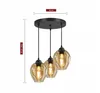 A three-light pendant lamp with amber glass shades and a black metal base, shown with dimensions indicated. Produktbild-Vorschau