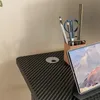 A close-up view of a desk surface with office supplies and a laptop. Produktbild-Vorschau