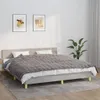 A bed with a gray blanket and pillows in a room. Náhľad obrázku produktu