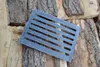 A metal grate lies on a pile of firewood. Náhled obrázku produktu