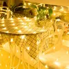 A table covered with a checkered tablecloth and decorated with fairy lights, with chairs around it. Náhled obrázku produktu