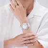 A close-up shot of a person's wrist wearing a watch and rings, against a white background. Voir les images du produit