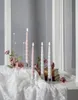 Four LED candles in glass holders are arranged on a white lace tablecloth, with roses and books in the background. Produktbild-Vorschau
