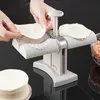 A person is using a dumpling maker to prepare dumplings. Podgląd zdjęcia produktu