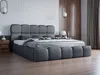 A modern bedroom with a large upholstered bed.