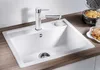 A white kitchen sink with a chrome and white faucet, set on a wooden countertop. A waffle maker and waffles are visible in the background. Produktbild-Vorschau