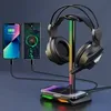 A gaming headset stand with RGB lighting, charging two smartphones and a wireless charging pad for a third phone. Podgląd zdjęcia produktu