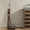 A close-up of a rustic dresser and decorative elements against a patterned wallpaper. Produktbild-Vorschau