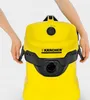 Hands holding the sides of a yellow Kärcher vacuum cleaner. Podgląd zdjęcia produktu