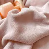A close-up view of soft, pink, plush fabric, likely bedding, with a hint of a light pink object in the background. Produktbild-Vorschau