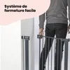 A person is shown operating a safety gate, demonstrating its easy closing mechanism. Voir les images du produit