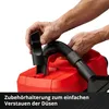 A person is demonstrating how to attach an accessory to a red wet and dry vacuum cleaner. Produktbild-Vorschau