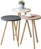 Three nesting tables of different sizes and colors, with a plant and a book on the largest table and a cup of coffee on the smallest table. Produktbild-Vorschau