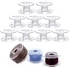 A collection of clear plastic sewing machine bobbins, some empty and some filled with thread in different colors. Produktbild-Vorschau