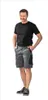 A man is standing and posing for a product photo, wearing shorts and a t-shirt. Produktbild-Vorschau