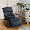 A dark gray upholstered rocking chair is shown in a living room setting, with a white door in the background and a sofa and plants visible on the right. Náhled obrázku produktu