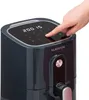 A hand is pressing a button on the digital display of a dark gray air fryer. Produktbild-Vorschau