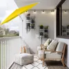 A balcony scene with furniture, plants, and a yellow umbrella. Produktbild-Vorschau