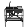 A black double basin kitchen sink with a black faucet and plumbing is shown against a white background. Produktbild-Vorschau