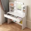 A white vanity table with a mirror and LED lights, filled with makeup and accessories, placed on a wooden floor next to a window with curtains. Náhled obrázku produktu