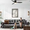 A woman reads a book on a sofa while a child plays on the floor in front of it. Voir les images du produit