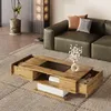A living room scene with a coffee table in the foreground and a sofa in the background. Produktbild-Vorschau