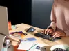 A person's hands are typing on a keyboard while a trackball mouse is next to it on a desk with various office supplies. Anteprima dell’immagine prodotto