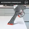 A close-up of a handheld vacuum cleaner being used on a white surface, with kitchen cabinets and a stovetop visible in the background. Produktbild-Vorschau