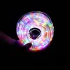 A hand holding a coiled string of colorful LED lights against a black background. Produktbild-Vorschau