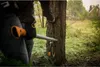 A person is using a Fiskars WoodXpert felling lever with a hook to assist in felling a tree in an outdoor setting. Produktbild-Vorschau