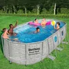 A family is enjoying a swim in an oval above-ground pool on a sunny day. Produktbild-Vorschau