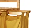 A close-up view of a bamboo laundry basket with yellow fabric bags. Produktbild-Vorschau
