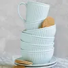 A stack of pale blue ceramic bowls and a mug, with cookies. Produktbild-Vorschau