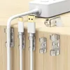 Durchsichtige Klebebefestigungen organisieren weiße USB-C- und USB-A-Kabel auf einer hellen Holzoberfläche, mit einer weißen Steckdosenleiste im Hintergrund Productafbeelding-voorbeeld