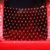 A red net light curtain is draped over bushes and illuminated at night, with two large pillars on either side. Produktbild-Vorschau