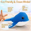 A plush whale toy on a beach with a starfish. Produktbild-Vorschau