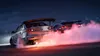 Two cars drifting at night, creating pink smoke. Produktbild-Vorschau