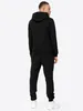 A man wearing a black tracksuit, viewed from the back. Produktbild-Vorschau