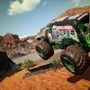 A monster truck, Grave Digger, is shown in mid-air, jumping over a dirt track in a desert-like environment with rocky hills and sparse vegetation under a cloudy blue sky. Produktbild-Vorschau