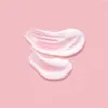 A close-up shot of a swirl of white cream with pink undertones on a light pink background. Podgląd zdjęcia produktu