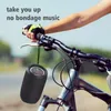 A person's arm and hand holding a bicycle handlebar, with a portable speaker hanging from it. Produktbild-Vorschau
