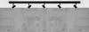 A black track light fixture with five adjustable spotlights mounted on a black rail, positioned against a concrete wall. Náhľad obrázku produktu
