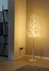A decorative LED light tree is placed in a corner of a room, near a bookshelf and a wall outlet. Produktbild-Vorschau