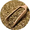 A wooden scoop filled with yerba mate tea leaves, resting on a pile of more tea leaves. Produktbild-Vorschau