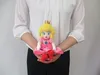 A person holding a Princess Peach plush toy. Náhľad obrázku produktu