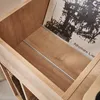 A close-up view of a wooden record cabinet, showing the interior with vinyl records and a record sleeve. Anteprima dell’immagine prodotto