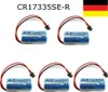 Five Mitsubishi CR17335SE-R batteries with wires and connectors are arranged in two rows on a white background. A German flag is in the top right corner. Produktbild-Vorschau