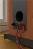 Close-up of the back of a wooden speaker with a port and two binding posts connected to red and black wires. Anteprima dell’immagine prodotto