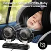 A baby sleeping in a car seat with two fans blowing air towards it. Produktbild-Vorschau